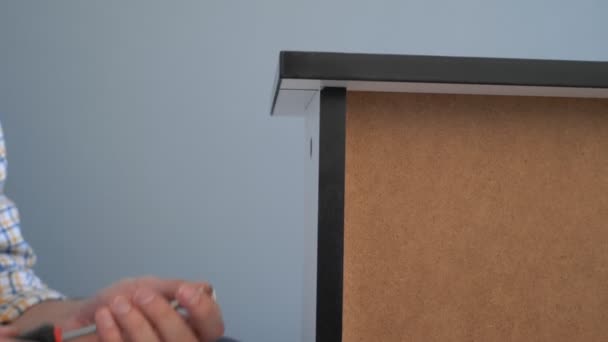 Närbild. manliga händer skruva fast skruven på en möbel med en skruvmejsel — Stockvideo