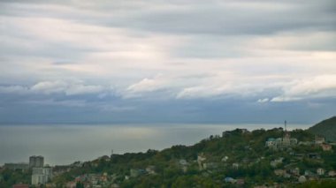 Gün batımında deniz kıyısında hareket eden bulutlar