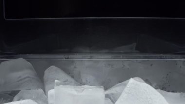 Son derece yakın plan, detaylı. Plastik şeffaf bir kabın içindeki buz küpleri
