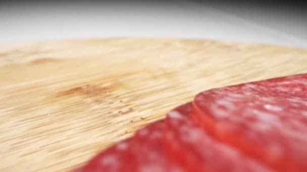 Close-up extremo, detalhado. salsicha de salame cortada em pedaços finos em uma placa de madeira — Vídeo de Stock