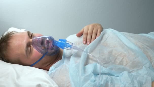 Portrét muže v kyslíkové masce, který leží na posteli v nemocnici — Stock video