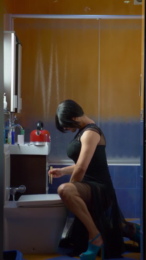 Dikey olarak. Tuvaletten erişte yiyen kadın kılığına girmiş bir adam. — Stok video