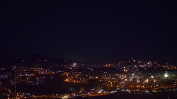 Muitos flashes de fogos de artifício sobre a cidade noturna. feriado geral — Vídeo de Stock