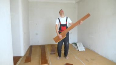 Tulum giymiş, lamine bir tahtanın üzerinde gitar çalıyor gibi yapan bir adam.