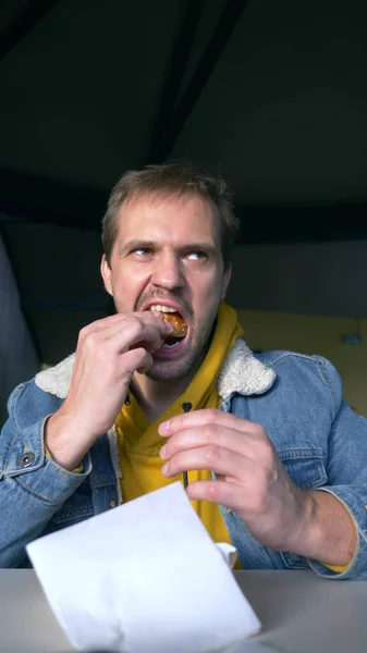 Retrato de homem com raiva comendo hambúrguer no café fast food — Fotografia de Stock