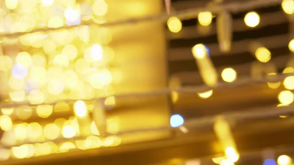 Fundo desfocado. espaço de cópia. Luzes douradas guirlanda com flares azuis — Fotografia de Stock