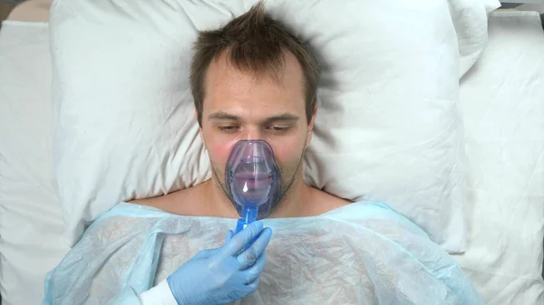 病院のベッドの上に横たわる酸素マスクの男の肖像画 — ストック写真