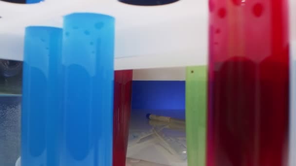 Extreem close-up, gedetailleerd. reagentia in potten en reageerbuizen met veelkleurige vloeistof — Stockvideo