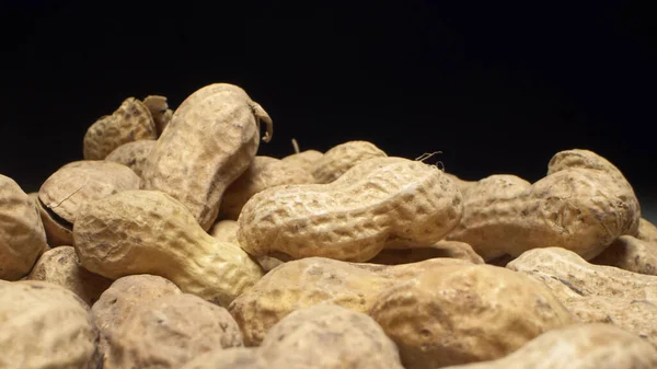 Extremely close-up, detailed. peanuts in shells on a dark background — Stock Photo, Image