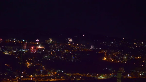 Muchos destellos de fuegos artificiales sobre la ciudad nocturna. vacaciones generales — Foto de Stock