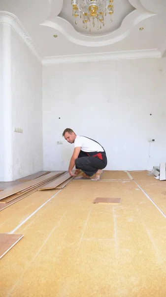 Close-up. construtor masculino quebra o piso laminado velho no apartamento — Fotografia de Stock