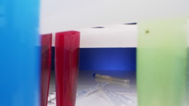 Extreem close-up, gedetailleerd. reagentia in potten en reageerbuizen met veelkleurige vloeistof — Stockvideo