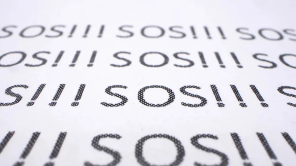Background text. extremely close-up, detailed. words sos printed on paper — Stock Photo, Image