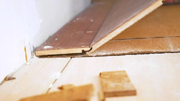Close-up. tukang bangunan laki-laki istirahat lama laminasi lantai di apartemen — Stok Foto