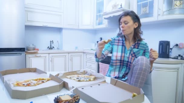 Alegre divertida mujer comiendo pizza fuera de la caja en casa en la cocina — Vídeos de Stock