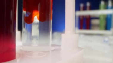  Kimyasal deneyler. Kırmızı sıvı, test tüpündeki temiz bir sıvıda çözünür.