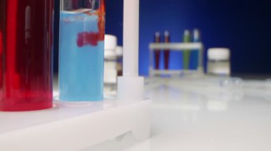  Kimyasal deneyler. Kırmızı sıvı, test tüpündeki temiz bir sıvıda çözünür.