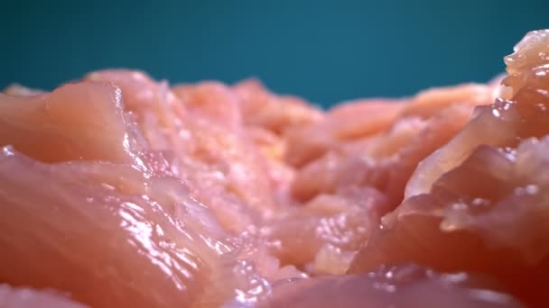 Extremely close-up, detailed. sliced chicken fillet on a blue background — Stock Video