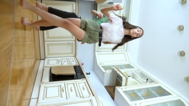 Vertical video. funny guy and girl dancing together at home in the kitchen — Stock Video