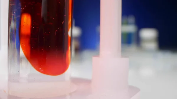 Experiências químicas. líquido vermelho dissolve-se num líquido límpido num tubo de ensaio — Fotografia de Stock