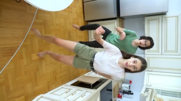 Vertical video. funny guy and girl dancing together at home in the kitchen — Stock Video