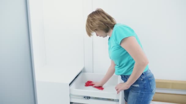 Mujer haciendo limpieza en casa limpiando polvo en el armario con un trapo rojo — Vídeos de Stock