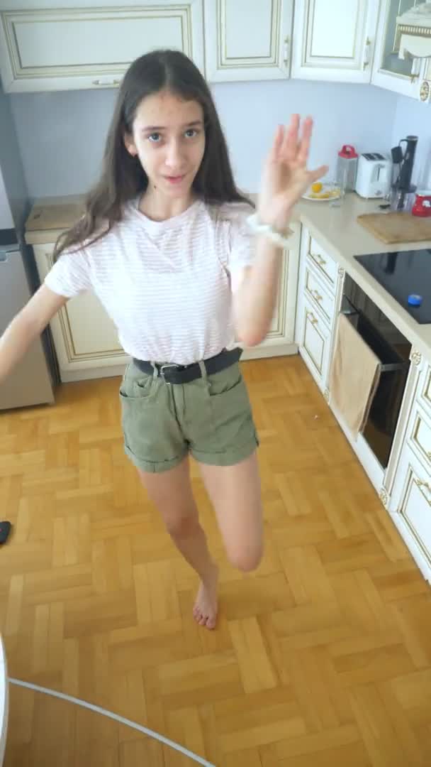 Pionowe wideo. piękna dziewczyna tancerka radośnie tańczyć w domu w kuchni — Wideo stockowe