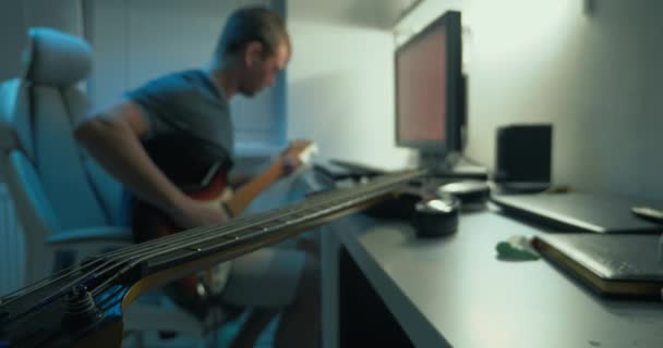 Hombre escribe música electrónica en casa en la mesa delante del monitor — Vídeos de Stock