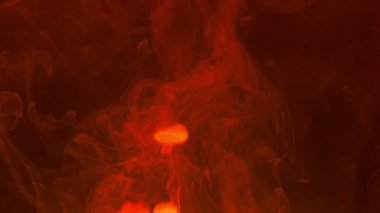 Soyut arkaplan. Kırmızı boya, koyu bir arkaplanda suda çözünür, boşluğu kopyala