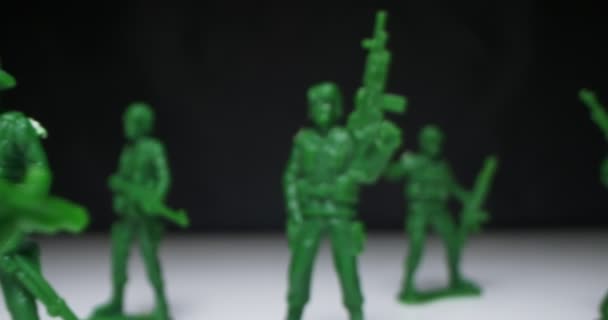 Detailed extreme close-up plastic green toy soldiers arranged on black background — Stock Video