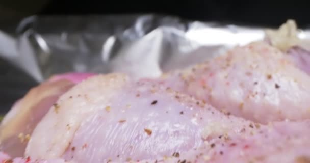 Detaillierte extreme Nahaufnahme des Kochprozesses gewürzter Hühnerkeulen in Folie — Stockvideo