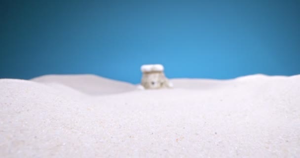 Detallado primer plano extremo de dolmen miniatura en arena blanca sobre fondo azul — Vídeo de stock