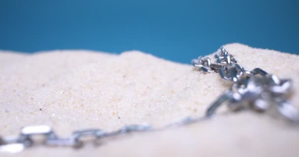 Detaillierte extreme Nahaufnahme Silberkette auf weißem Sand — Stockvideo