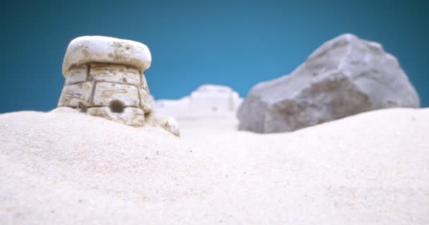 Detallado primer plano extremo de dolmen miniatura en arena blanca sobre fondo azul — Vídeos de Stock