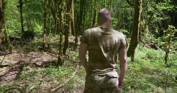 Guapo hombre brutal deportista corriendo en el bosque en ropa caqui especial — Vídeos de Stock