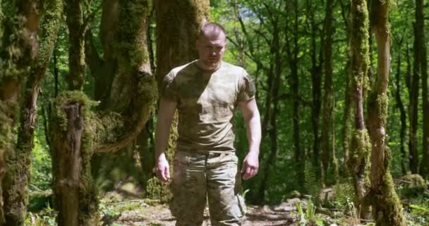 Guapo hombre brutal deportista corriendo en el bosque en ropa caqui especial — Vídeos de Stock