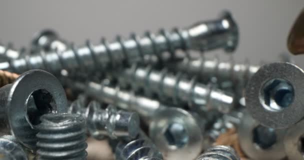 Detailed extreme close-up of a lot of screws. industrial background — Stock Video