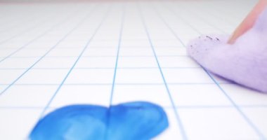 Detaylı, aşırı yakın plan, bir kadın eli bez parçasıyla beyaz tahtadaki çizimleri siler.