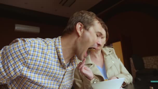 Pari mies ja nainen lounastaa yhdessä kahvilassa — kuvapankkivideo
