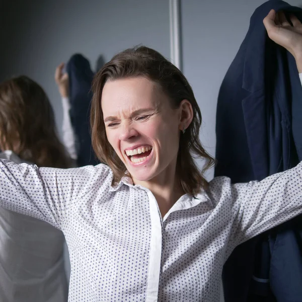 Porträt einer emotionalen Geschäftsfrau, die ihre Jacke auszieht und glücklich lächelt Stockbild