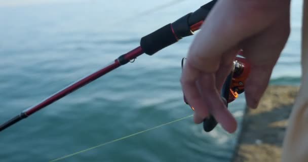 Primer plano de las manos femeninas girando el carrete en la varilla giratoria. mujer pesca — Vídeos de Stock