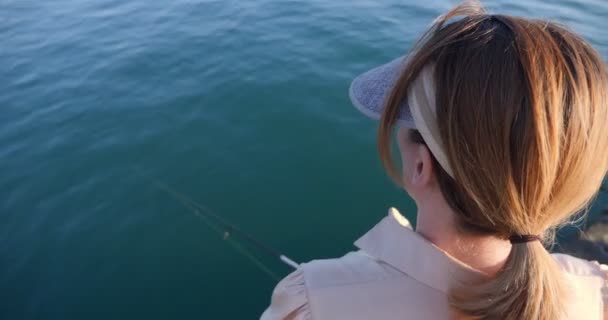 穿着连衣裙的漂亮女人在海里用纺锤钓鱼 — 图库视频影像