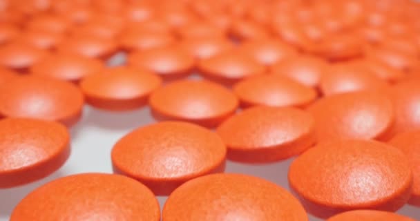 Medische achtergrond. gedetailleerde close-up van rode ronde pillen op wit oppervlak — Stockvideo