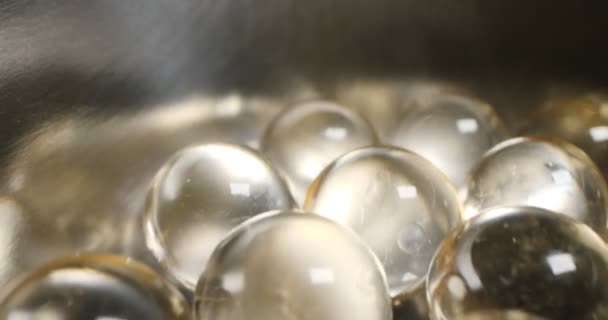 Detailed, extreme close-up of round transparent pills. fat-soluble vitamins — Stock Video