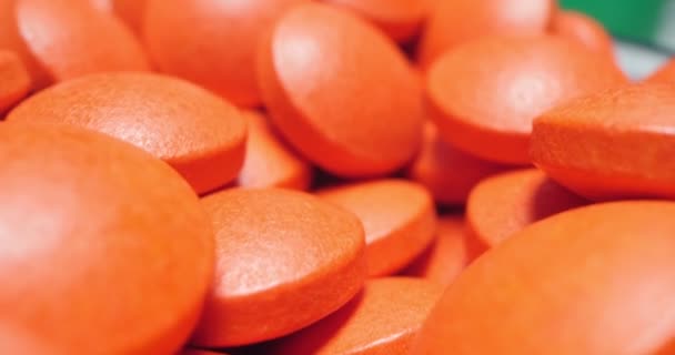 Lékařské zázemí. detailní detailní záběr červené kulaté pilulky na bílém povrchu — Stock video