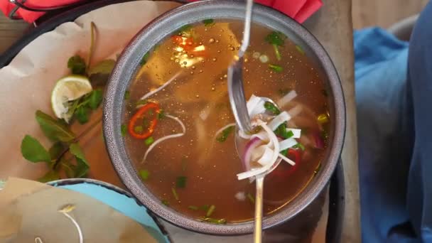 Primo piano vista dall'alto, qualcuno che mangia zuppa pho bo con forchetta e cucchiaio da piatto grande — Video Stock