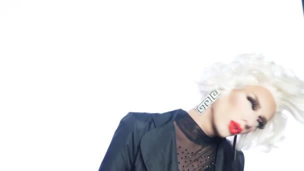 Porträtt, travesti man i bilden av en blondin med röda läppar dansar på en vit bakgrund — Stockvideo