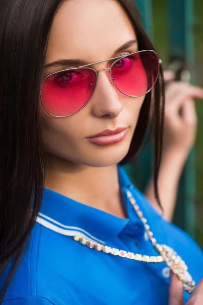 Sexy girl in pink glasses and a necklace — Stock Photo, Image
