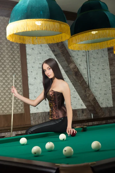Sexy girl in corset plays billiards. — Stock Photo, Image