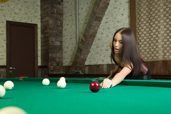 Sexy girl in corset plays billiards. — Stock Photo, Image